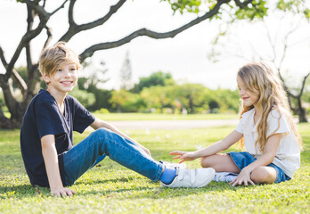 Fototapeta premium Brother and sister playing together at the park in the morning sunrise