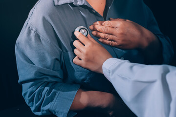 Cropped image of male doctor's hand using stethoscope to examining heartbeat and symptom of patient...