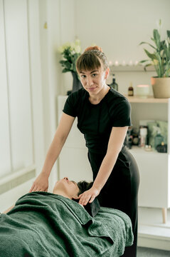 Young woman massagist making massage to her client
