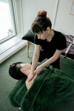 Young woman massagist making neck massage
