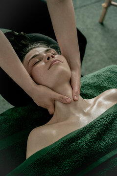 Young woman massagist making neck massage to client