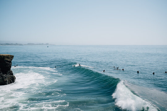 Surfers wading in pacific ocean waiting for waves
