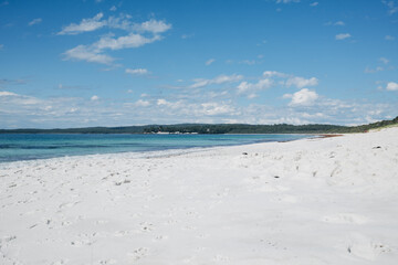 White sand beach and turquoise sea under blue sky at Jervis Bay