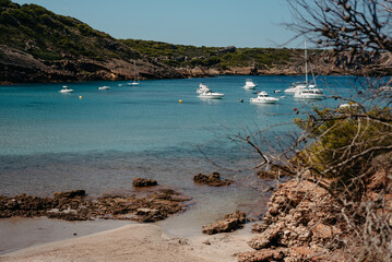 Obraz premium Anchored boats in turquoise waters at Cala Algaiarens, Menorca