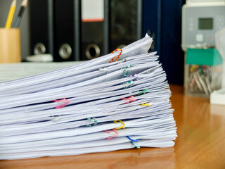A stack of stapled documents against a background of document folders