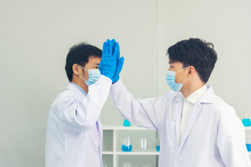 Two asian scientist men team high five partner shake hands together. Science Men research chemistry...