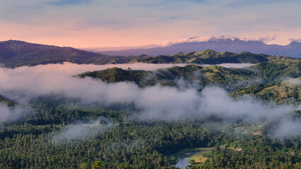 Misty Tropical Valley with Rolling Hills and Low Clouds at Sunrise