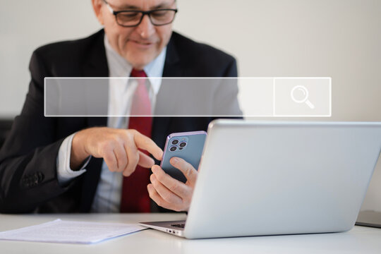 Businessman clicking internet search page on smartphone and computer touch screen in office..