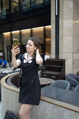 Fototapeta premium A business lady takes a selfie in front of a restaurant