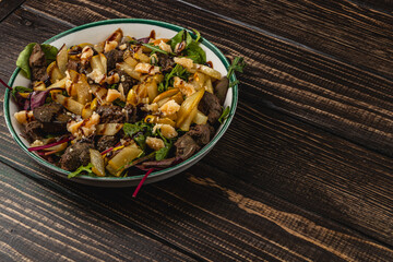 Delicious salad with beef, apples, and nuts on wooden table