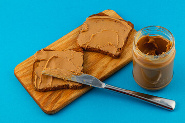Slices of brown bread topped with creamy peanut butter