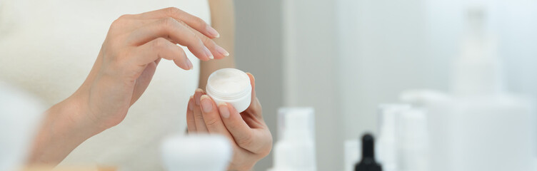 Beautiful Asian woman smile check cream for good skin. face of a healthy woman apply cream and makeup. Advertisement for skin cream, anti-wrinkle, baby face, whitening, moisturizer