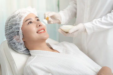 Beautiful woman receive spa and treatment skin of face. face of a healthy woman apply cream....