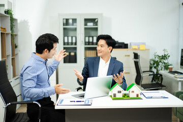 Professional team collaboration in modern office, discussing real estate model and signing contract, concept of startup