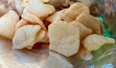 Crispy potato chips, delicious BBQ seasoning spicy for crips, slice deep fried snack fast food in open bag. Chips closeup photo.
