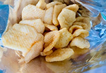 Crispy potato chips, delicious BBQ seasoning spicy for crips, slice deep fried snack fast food in open bag. Chips closeup photo.