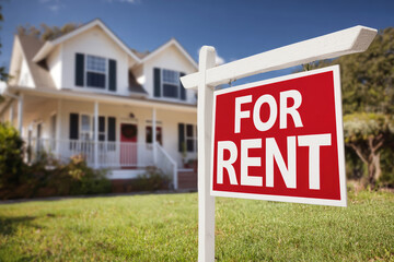 Charming house with a red for rent sign in front of a beautifully landscaped yard under a bright blue sky