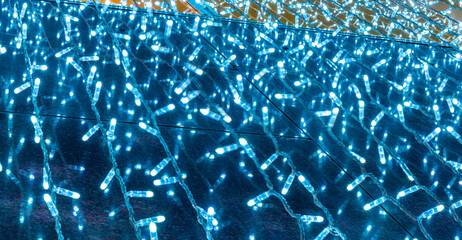 background of holiday colorful blue neon garland for texture and design, festive decoration close up