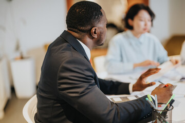A diverse group of people engaged in a business meeting within a modern office setting,...