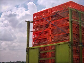 Chickens in orange crates being transported on a truck