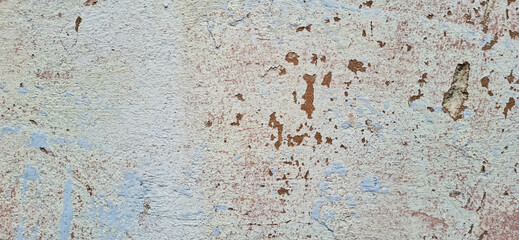 The texture of an aged wall with peeling paint.