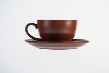 Brown coffee cup and coffee plate on white background
