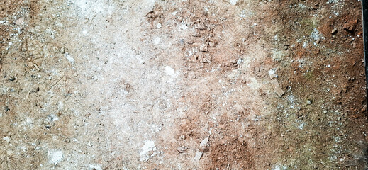 The floor texture of a collapsing building. Sand, cement, garbage.