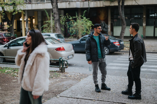 A group of young adults interact while standing near a busy street in an urban area. The scene portrays casual interaction among peers in a relaxed and social outdoor setting.