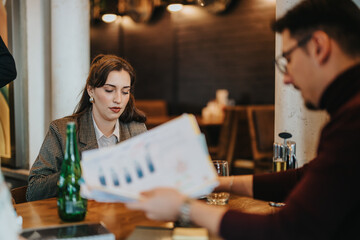 Team of businesspeople discussing projects while sitting at a modern cafe table. Collaborative interaction and reviewing documents reflect productive teamwork in a relaxed yet professional atmosphere.