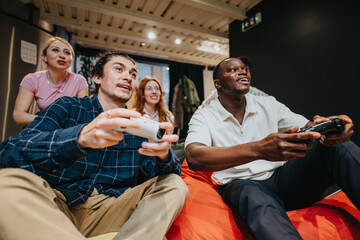 Enthusiastic colleagues sharing moments of fun and excitement while playing video games indoors, creating memories and enjoying the camaraderie of a group digital gaming session.