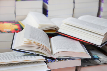 stack of books, close up. Open book on the table in library. Back to school concept.
