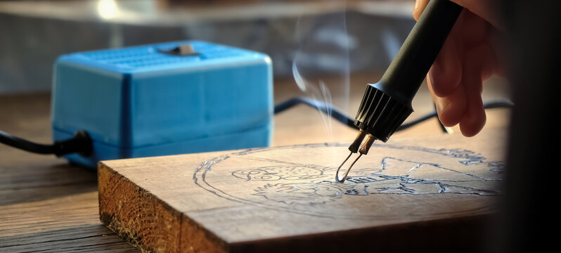 Burn out the picture. Woodburning or pyrography. An artist drawing on a wooden plank with pyrograph. Wood burning ASMR creative hobby. Art class workshop. Creative activity. High quality 4k footage.