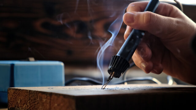 Burn out the picture. Woodburning or pyrography. An artist drawing on a wooden plank with pyrograph. Wood burning ASMR creative hobby. Art class workshop. Creative activity. High quality 4k footage.