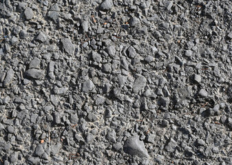 Ground surface with various rock textures and pebbles seen under bright sunlight at a construction...