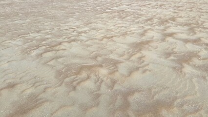 Unique Textures of Beach Sand Reveal Nature's Abstract Art Shaped by the Elements on a Serene Coastline at Sunrise