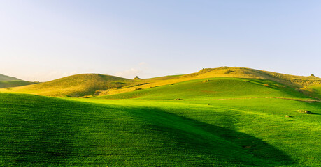 scenery rural view of a contryside farm in green fields and hills with amazing cloudy sky on...