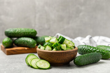 Cucumber on wooden background. Slice of cucumber on background. Fresh organic green cucumbers gherkin. Vegan. Salad ingredient. Farm vegetables. Cut vegetables with knife. Space for text. Copy space