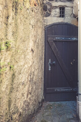 Hidden passage reveals ancient charm in a secluded alleyway with a historic door and weathered...