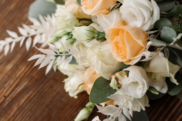 Wedding day. Photo of a wedding bouquet with gold wedding rings on a wooden background. Close-up