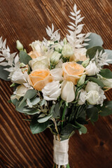 Wedding day. Photo of a wedding bouquet with gold wedding rings on a wooden background. Close-up