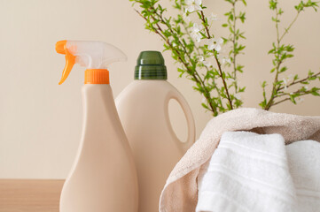 Eco natural household chemicals for home. Bottle with laundry detergent, folded bath towels and...