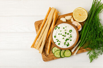 Cucumber sour cream tzatziki sauce on a wooden table.Tartar sauce. Traditional delicious appetizer. yogurt sauce. Tzatziki with ingredients cucumber, garlic,dill,lemon,mint. salad dressing.Copy space