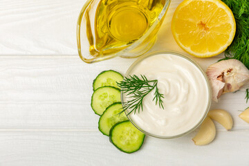 Cucumber sour cream tzatziki sauce on a wooden table.Tartar sauce. Traditional delicious appetizer. yogurt sauce. Tzatziki with ingredients cucumber, garlic,dill,lemon,mint. salad dressing.Copy space