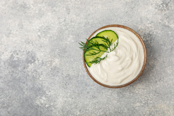 Cucumber sour cream tzatziki sauce on a wooden table.Tartar sauce. Traditional delicious appetizer. yogurt sauce. Tzatziki with ingredients cucumber, garlic,dill,lemon,mint. salad dressing.Copy space