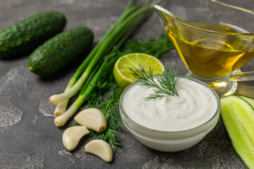 Cucumber sour cream tzatziki sauce on a wooden table.Tartar sauce. Traditional delicious appetizer. yogurt sauce. Tzatziki with ingredients cucumber, garlic,dill,lemon,mint. salad dressing.Copy space