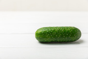 Cucumber on wooden background. Slice of cucumber on background. Fresh organic green cucumbers gherkin. Vegan. Salad ingredient. Farm vegetables. Cut vegetables with knife. Space for text. Copy space