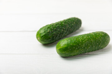 Cucumber on wooden background. Slice of cucumber on background. Fresh organic green cucumbers gherkin. Vegan. Salad ingredient. Farm vegetables. Cut vegetables with knife. Space for text. Copy space