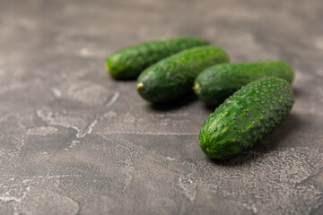 Cucumber on wooden background. Slice of cucumber on background. Fresh organic green cucumbers gherkin. Vegan. Salad ingredient. Farm vegetables. Cut vegetables with knife. Space for text. Copy space