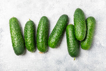 Cucumber on wooden background. Slice of cucumber on background. Fresh organic green cucumbers gherkin. Vegan. Salad ingredient. Farm vegetables. Cut vegetables with knife. Space for text. Copy space