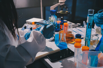 Scientist pipetting medical samples into microplate in laboratory